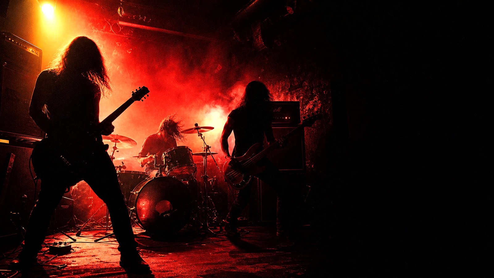 Groupe de rock en répétition sous une lumière rouge expressive